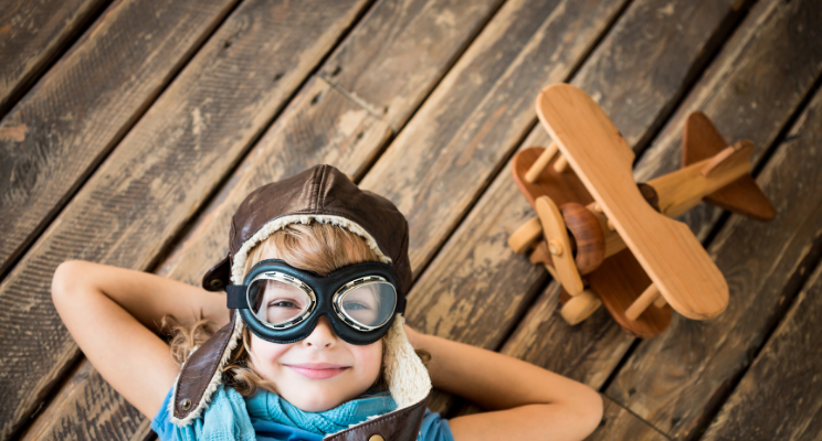 child next to toy airplane
